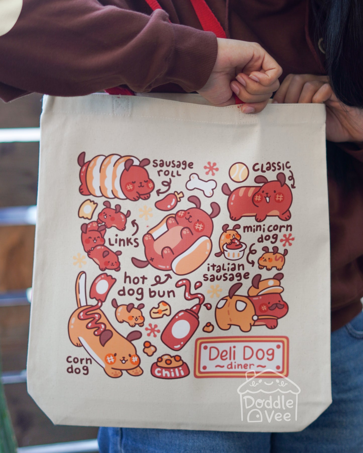 Tote bag with cartoon dog illustrations and text held by a person.