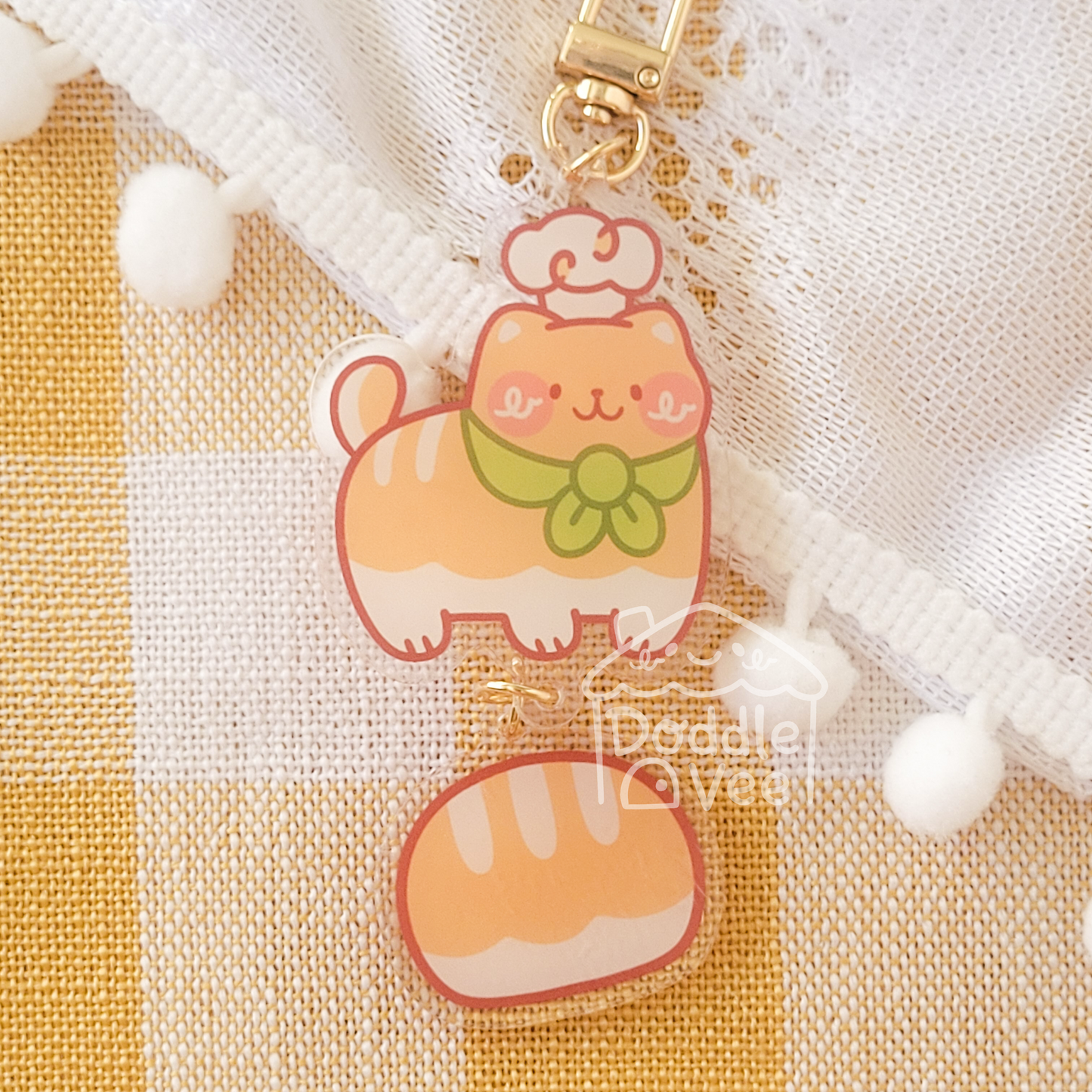 2.5 inch link keychain of an orange cat with a chef hat on the head. Second link keychain is 1.5 inches and is bread.