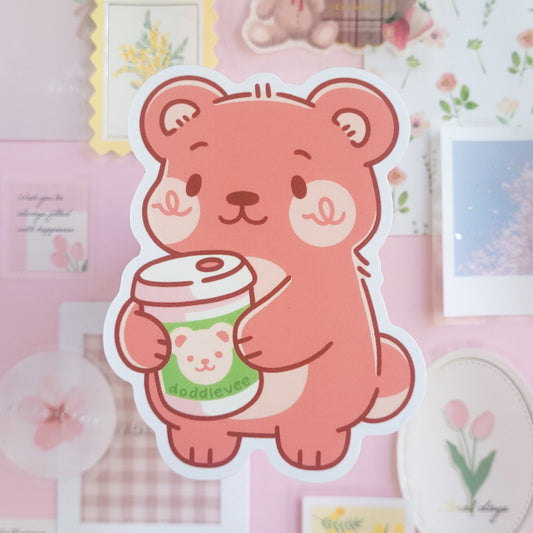 Sticker of pink bear holding a green hot coffee.
