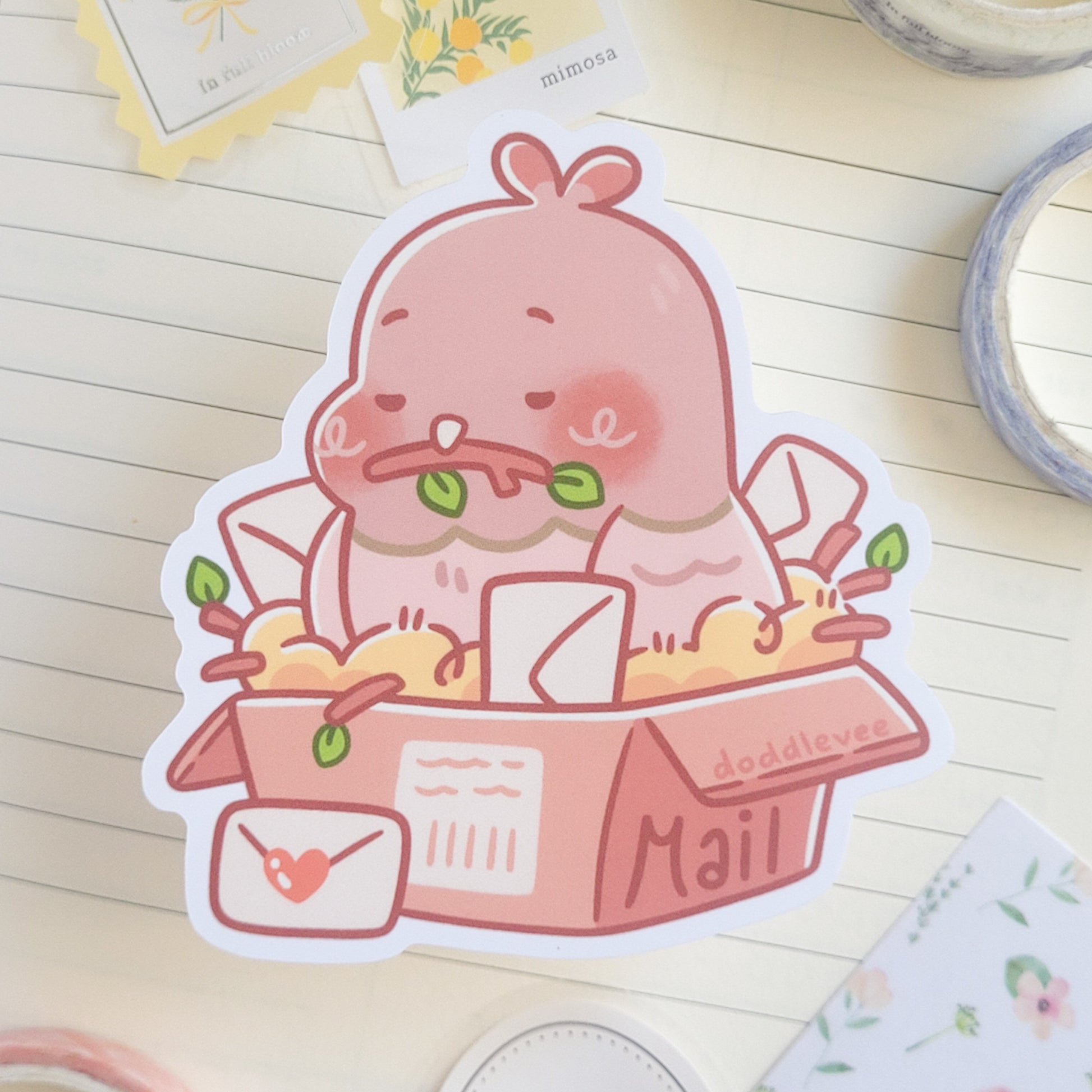Sticker with a pigeon sitting in a box that says mail holding a stick in its mouth