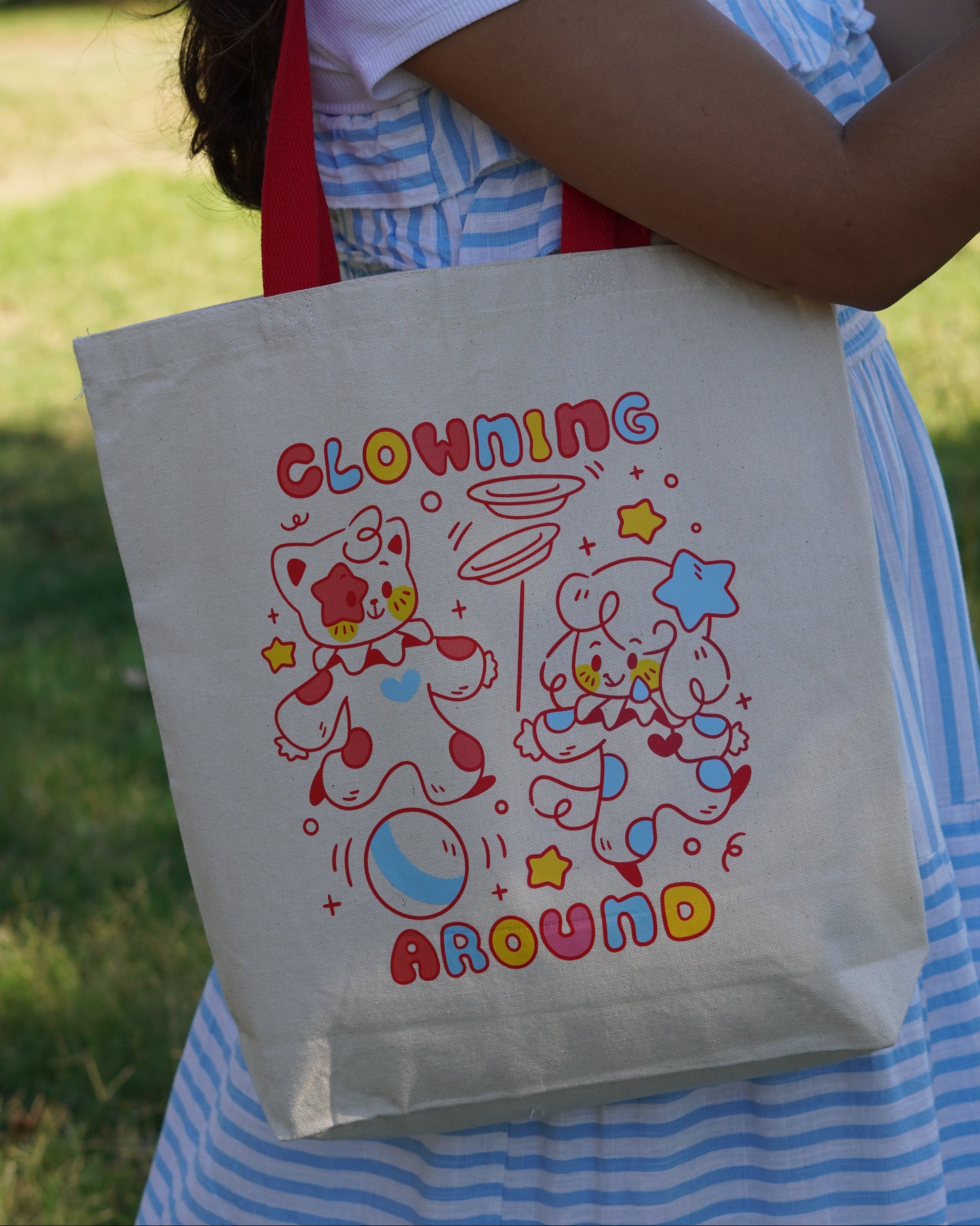 Person holding a tote bag with colorful designs and text.