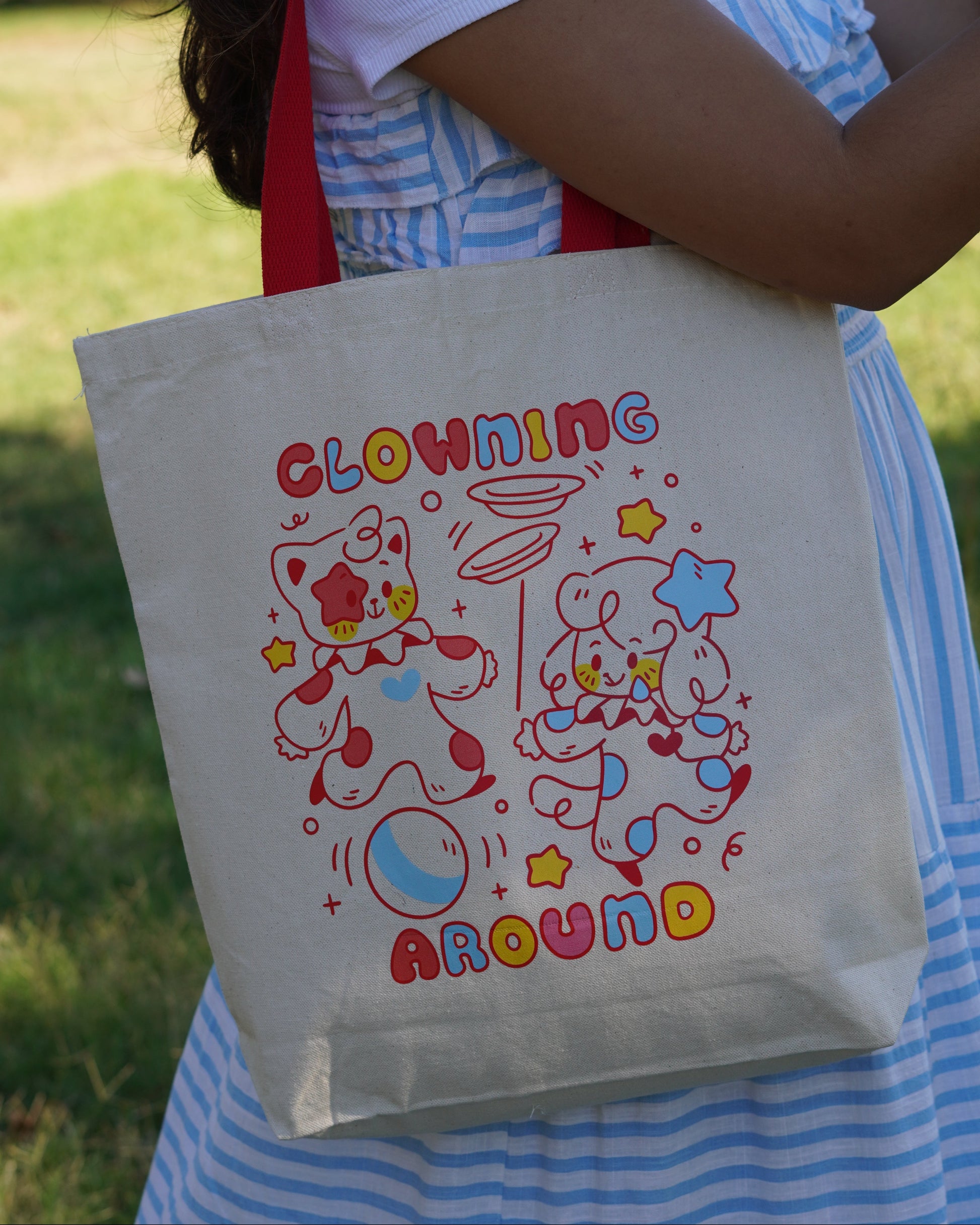 Person holding a tote bag with colorful designs and text.