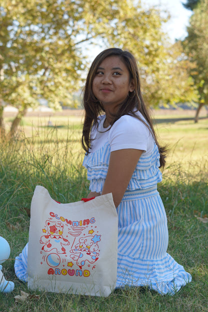 Woman holding a tote bag with colorful designs outdoors