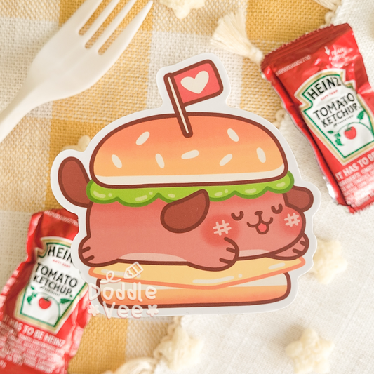 Cartoon hamburger sticker with Heinz ketchup packets on a yellow checkered tablecloth.