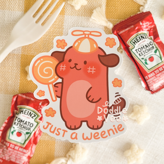 Sticker of a cartoon dog with a lollipop and Heinz ketchup packets on a checkered tablecloth.