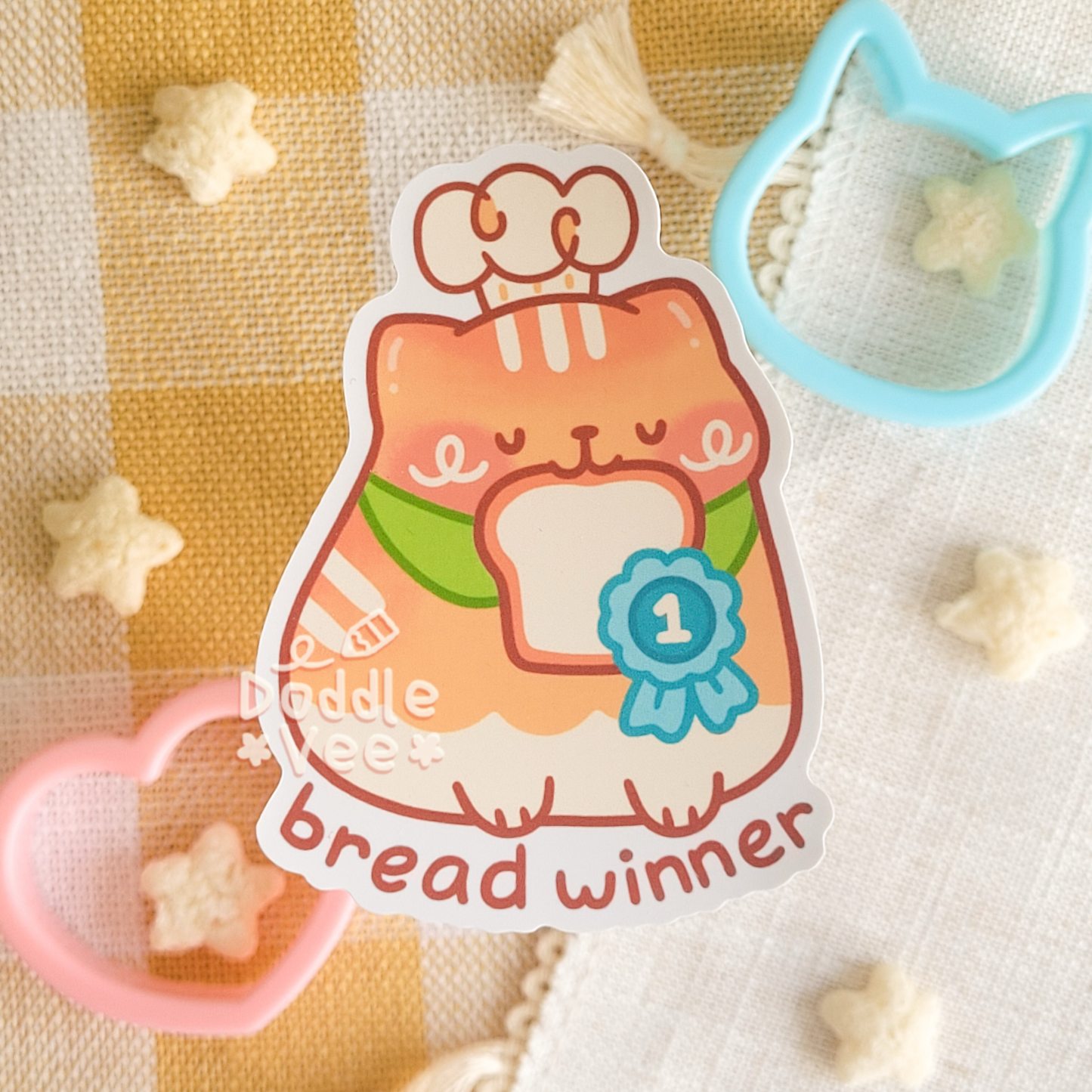 Sticker of orange cat with bread in its mouth. Text bread winner below it.