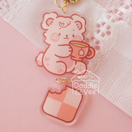 Link keychain of white bear holding tea cup and second link keychain is a cracker