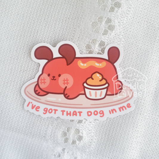 Sticker with a cartoon dog holding a cupcake on a white lace background