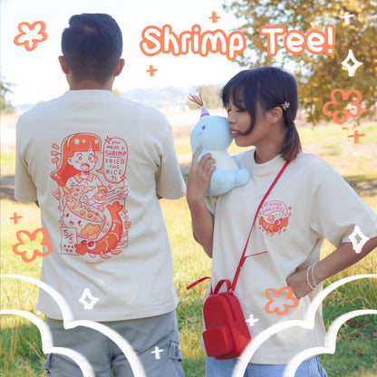 Two people wearing 'Shrimp Tee!' shirts in a park setting.