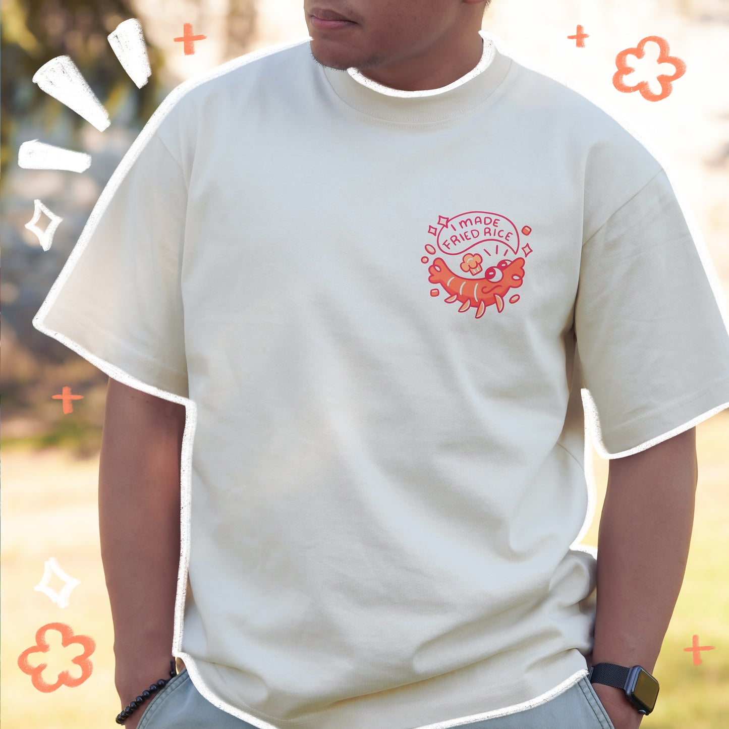 Person wearing a white t-shirt with a red logo, standing outdoors.