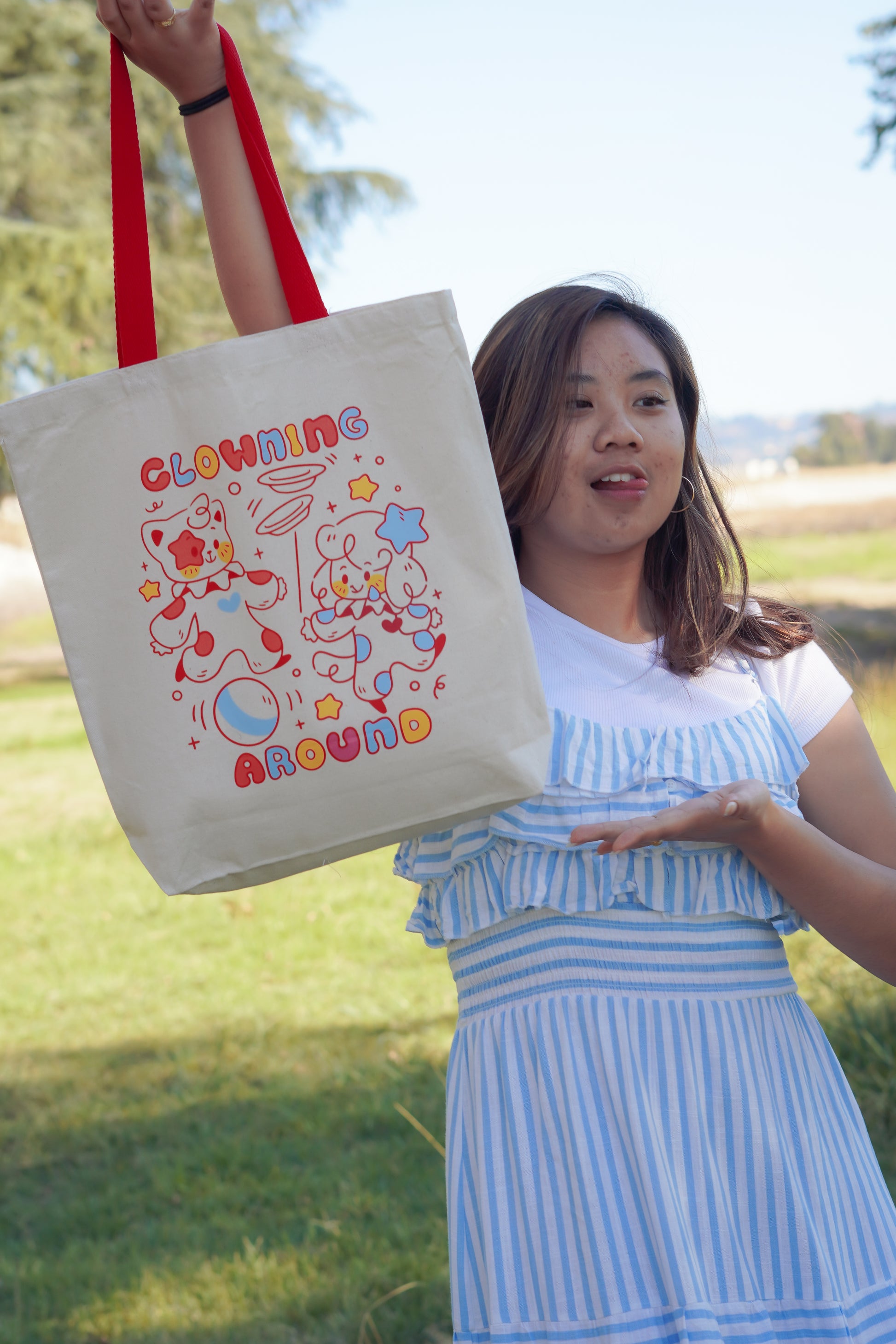 Woman holding a tote bag with colorful design outdoors
