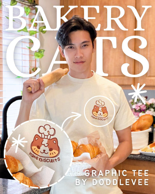 Person holding a baguette with 'Bakery Cats' graphic tee and plushie, featuring Doddlevee branding.